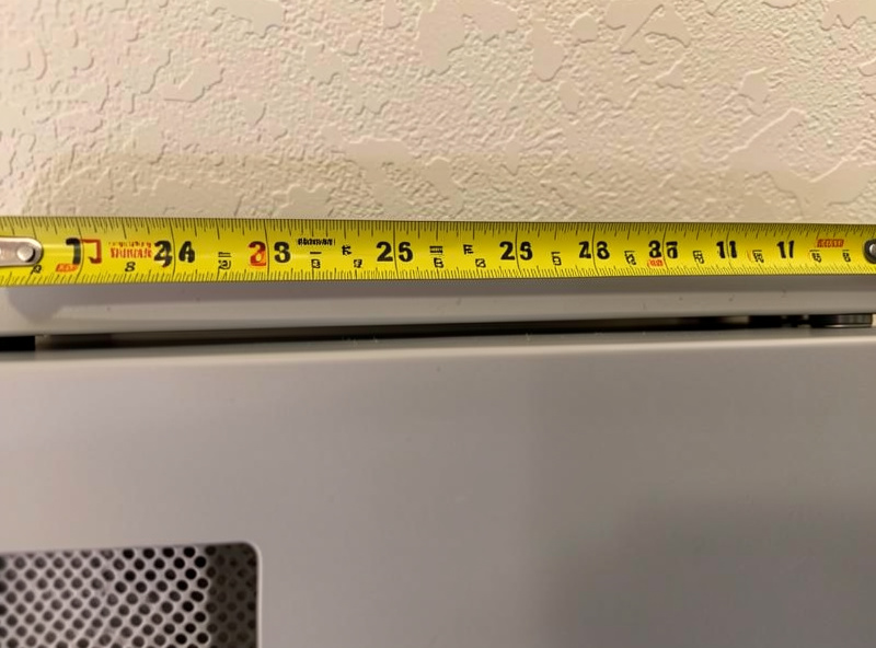 Tape measure showing the clearance gap behind and above a home freeze dryer against a wall