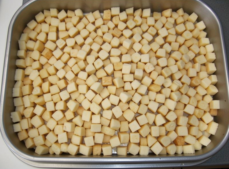 A freeze dryer tray loaded with an even single layer of diced food spread to the edges